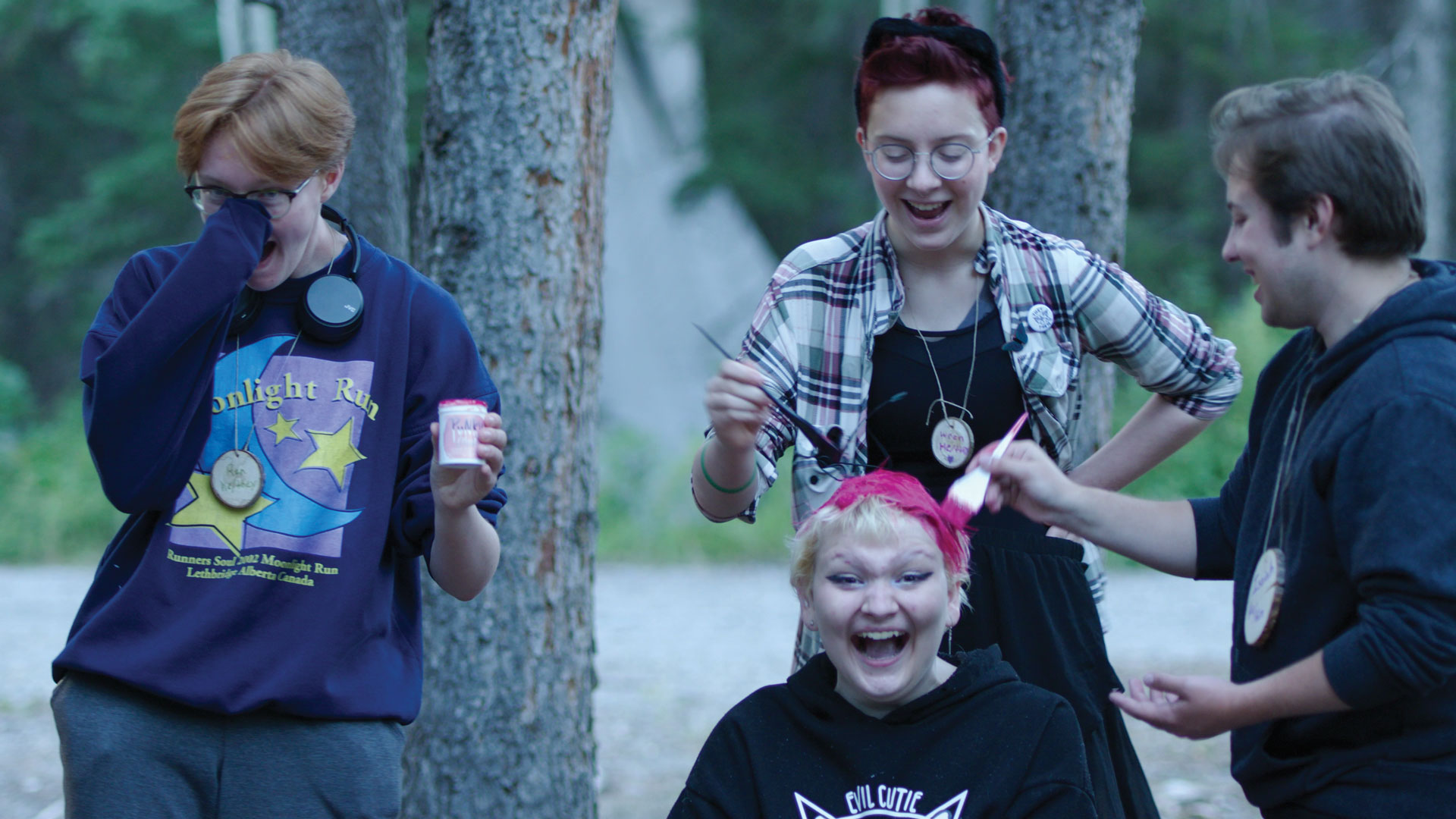 Summer Qamp film still featuring three youth dying another's hair and all happily laughing